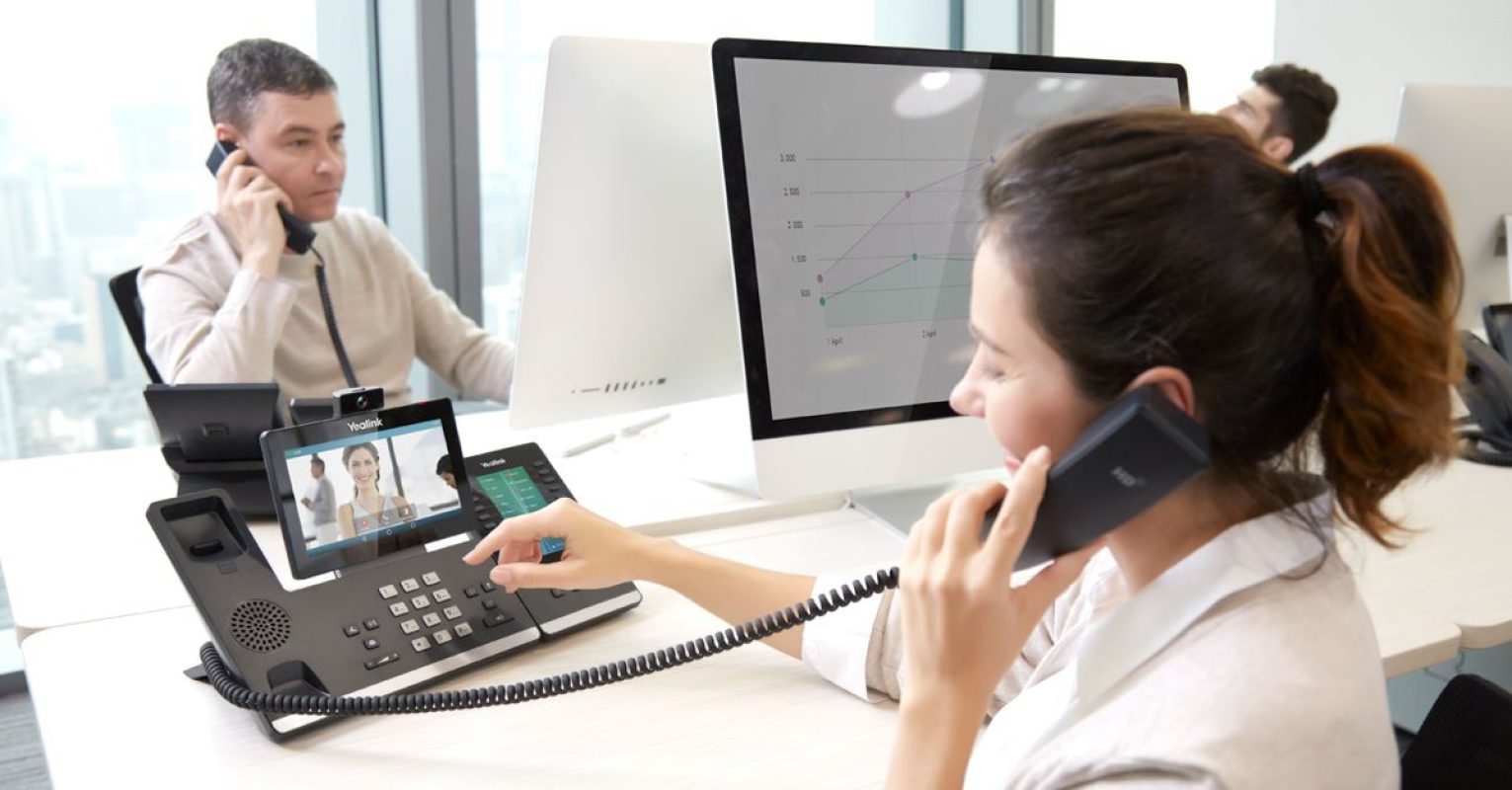 People on phone calls using VoIP in a unified communication system.